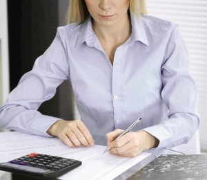 a woman using a calculator and spreadsheet